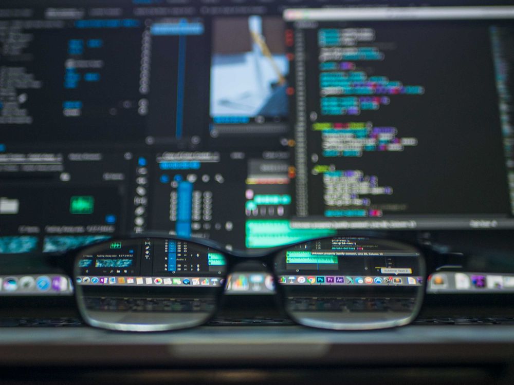 Lunettes reflétant des lignes de code sur un écran